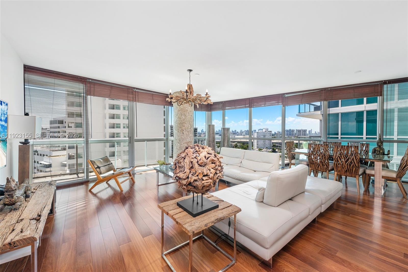 A bright living and dining area features floor-to-ceiling windows, hardwood floors, and modern furniture — 101 20th St # 1706, Miami Beach FL 33139, MIAMI BEACH, FL