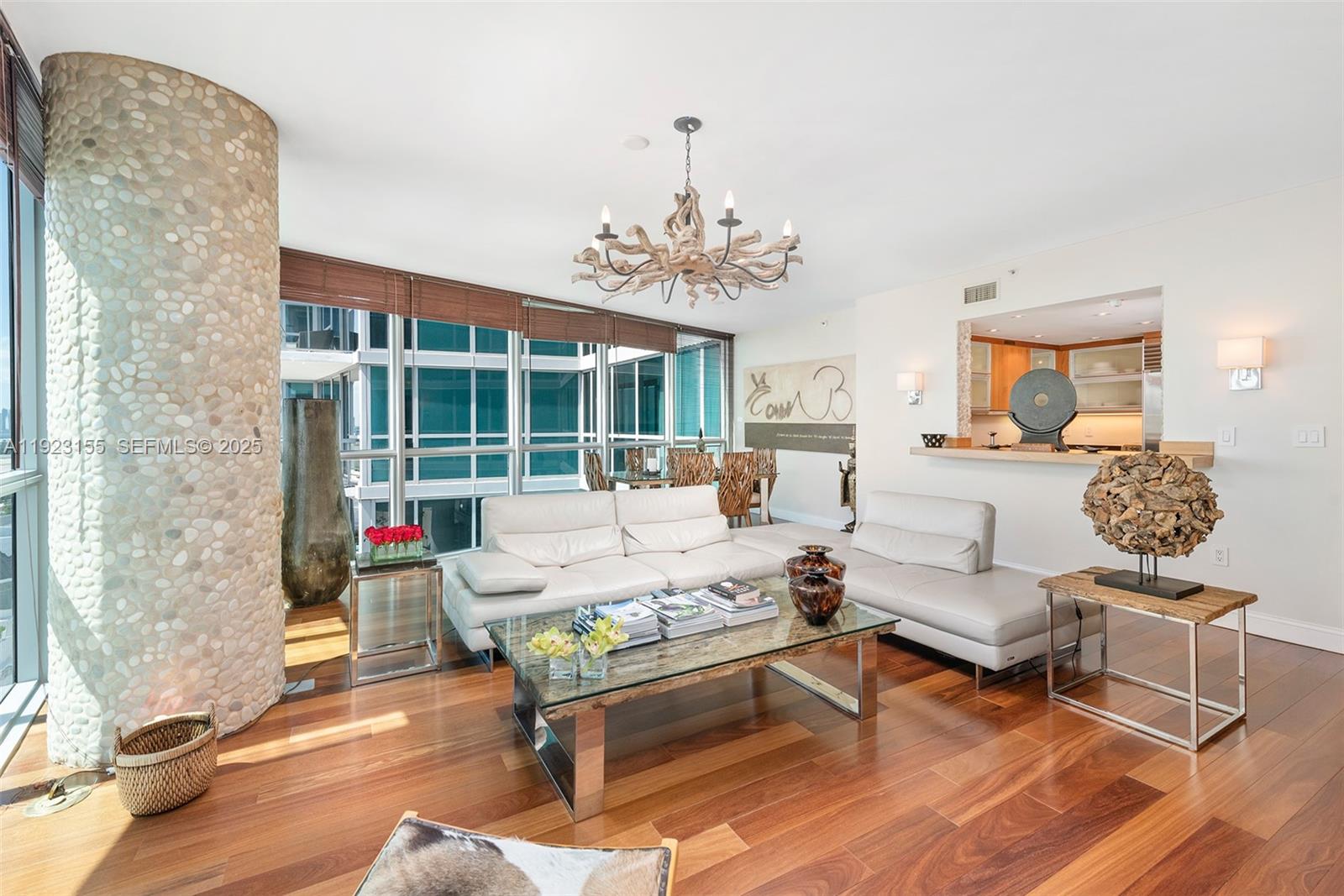 A living room features a pebble-covered column, a white sectional sofa, and a glass-topped table — 101 20th St # 1706, Miami Beach FL 33139, MIAMI BEACH, FL