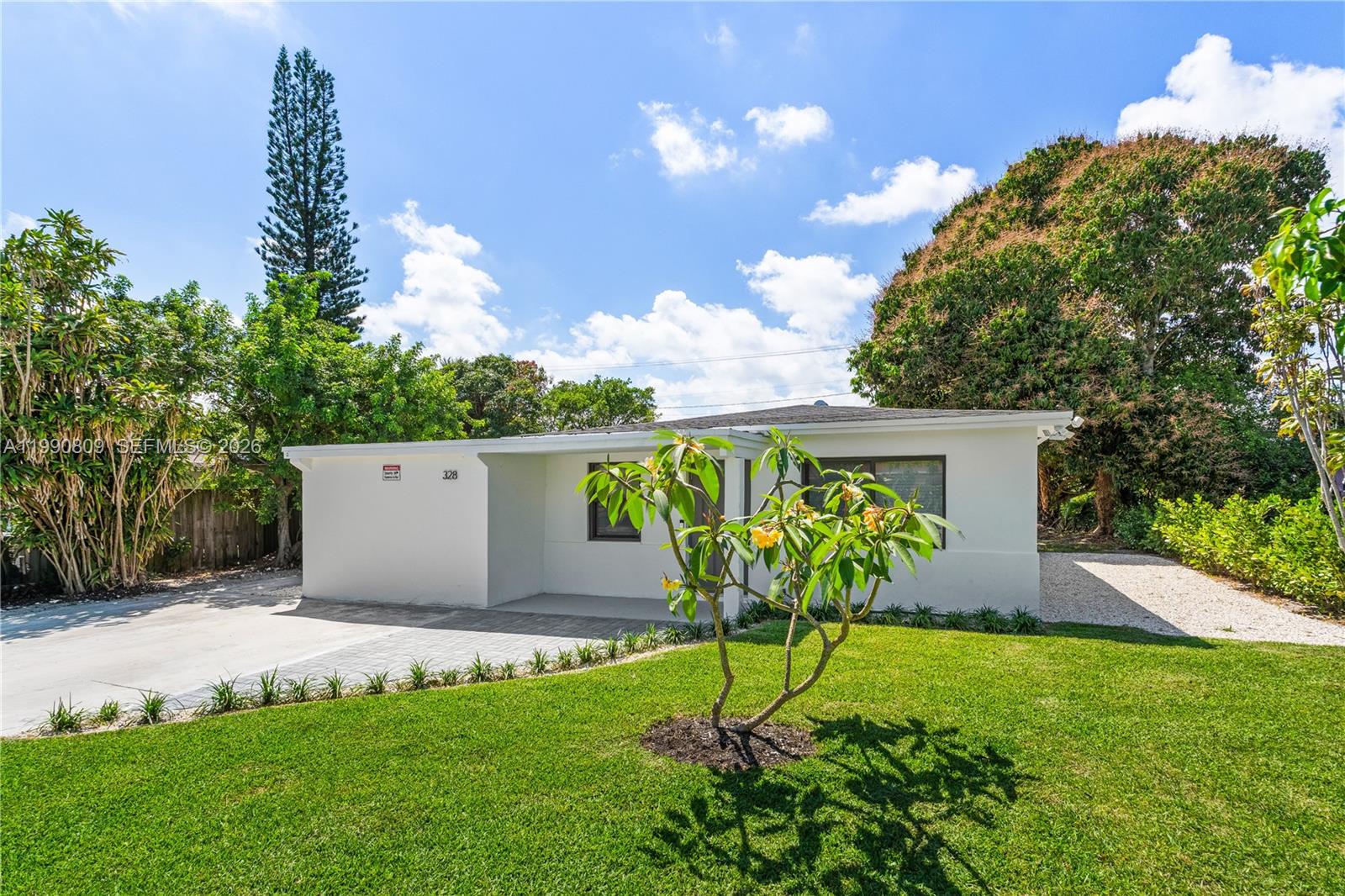 A single-story white house features a paved driveway, a front lawn, and a small tree — 328 SW 11th Ave, Delray Beach FL 33444, DELRAY BEACH, FL