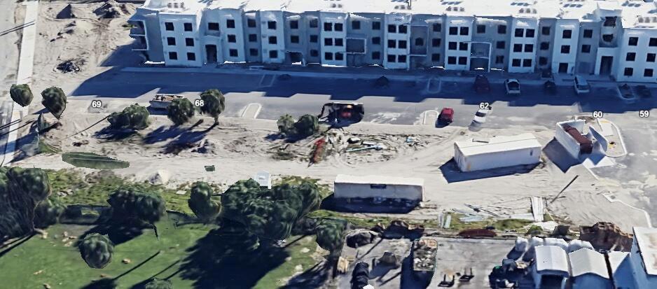 An aerial view shows a construction site with a large apartment building and storage containers — 3139 Lake Shore Drive, Riviera Beach FL 33404, RIVIERA BEACH, FL