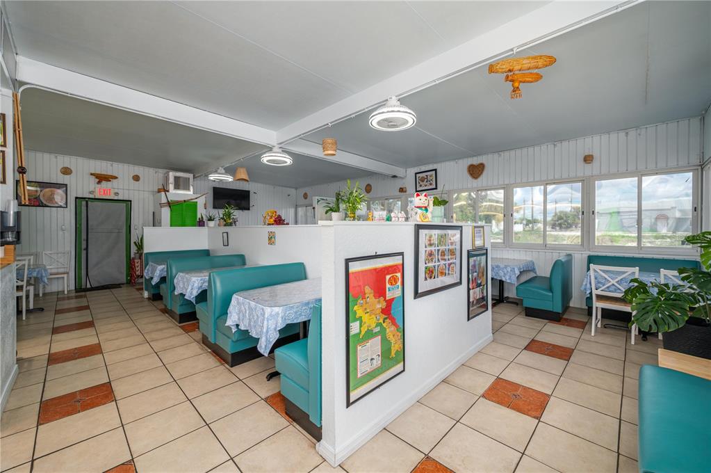A restaurant interior features teal booths, tiled floors, and a central partition wall with decor — 114 W CENTRAL AVENUE, LAKE WALES, FL