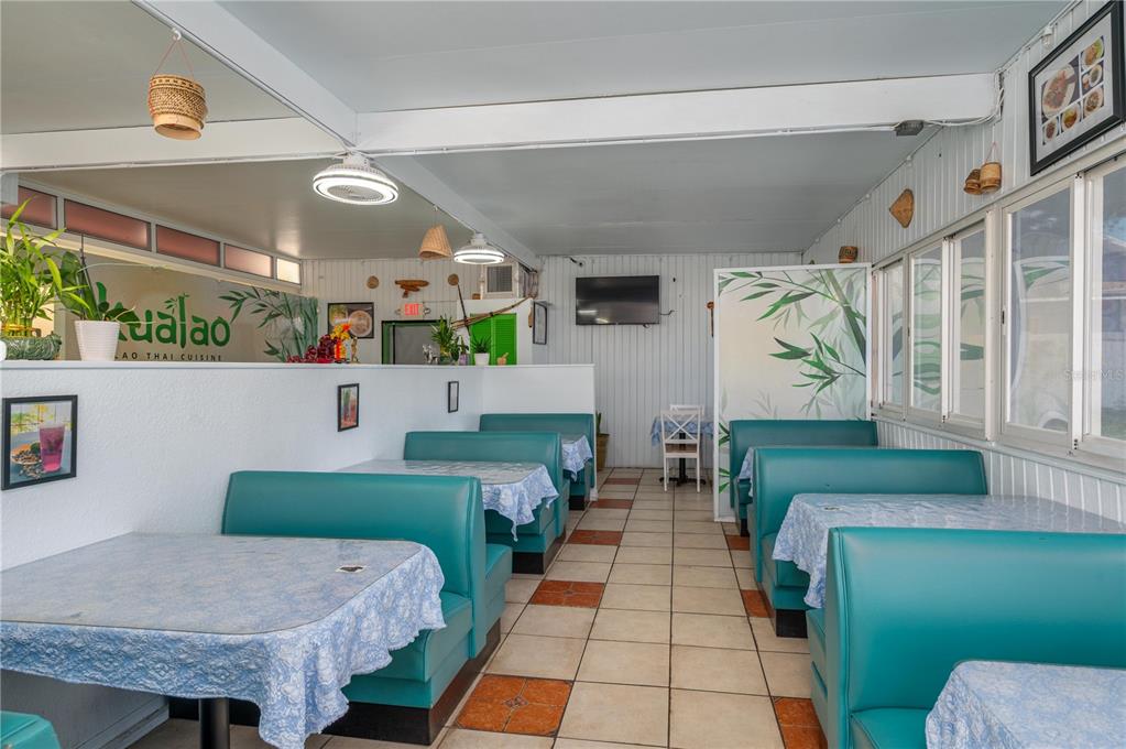 This restaurant dining area features teal booths, light blue patterned tablecloths, and tiled flooring — 114 W CENTRAL AVENUE, LAKE WALES, FL
