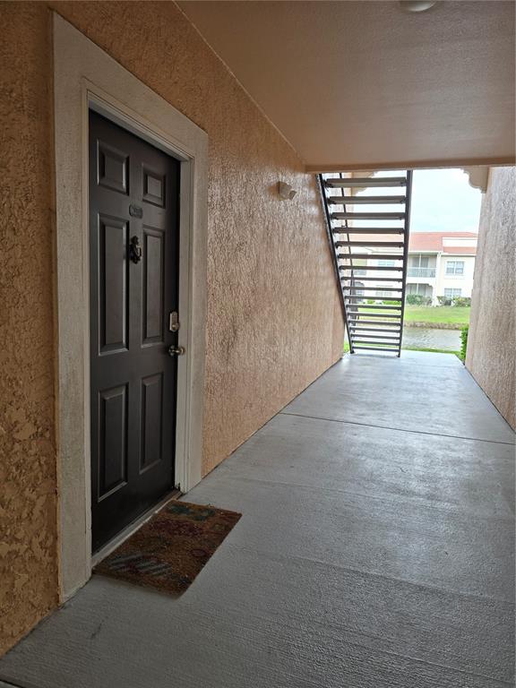 A dark brown front door with a door knocker sits on a concrete walkway — 4170 CENTRAL SARASOTA PARKWAY UNIT 412, SARASOTA, FL