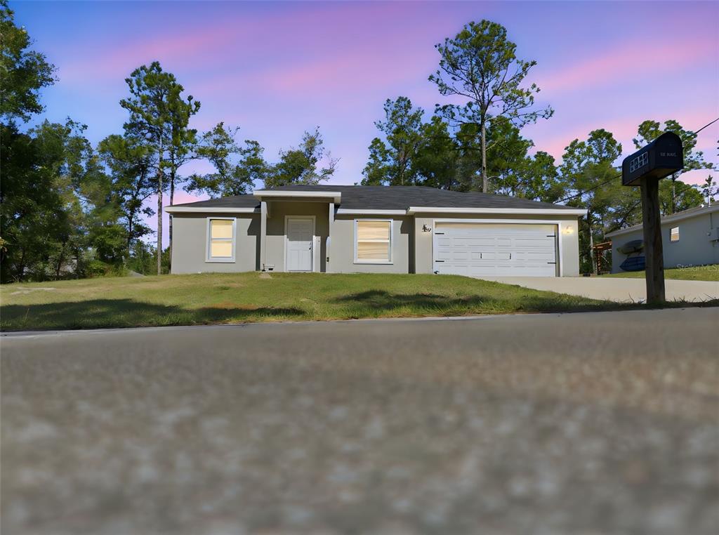 A single-story house with a gray exterior, a two-car garage, and a front lawn — 2039 W SHELLBARK DRIVE, CITRUS SPRINGS, FL
