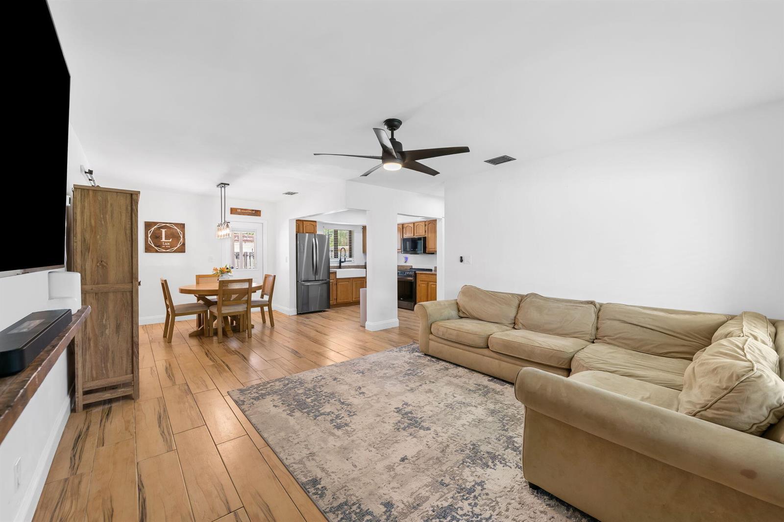 A living room with a sectional sofa, dining area, and kitchen with wood-look tile flooring — 1032 SW 1st Terrace, Pompano Beach FL 33060, POMPANO BEACH, FL