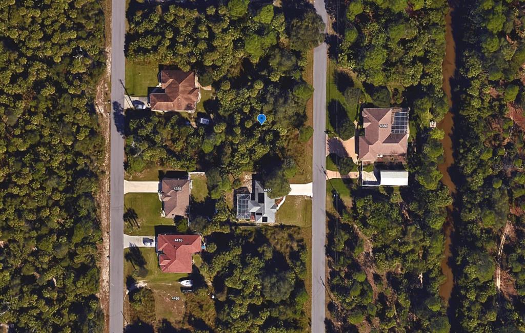 This is an aerial map view showing several houses surrounded by dense trees and vegetation — INVERNESS STREET, NORTH PORT, FL
