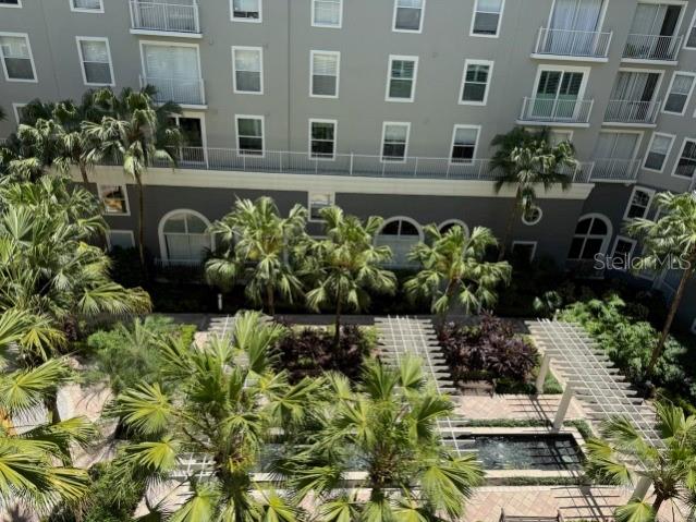 An elevated view shows a courtyard with palm trees, a water feature, and a multi-story building — 700 S HARBOUR ISLAND BOULEVARD UNIT 422, TAMPA, FL