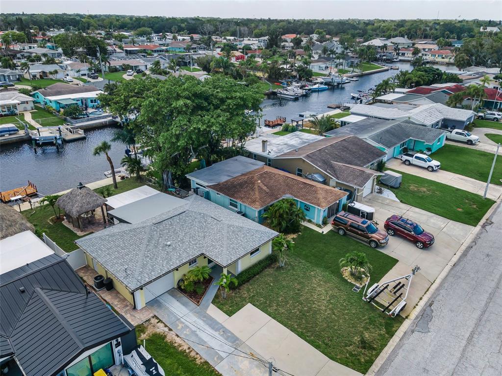 An aerial view shows several waterfront houses with driveways and boats docked in a canal — 4946 BLUE HERON DRIVE, NEW PORT RICHEY, FL