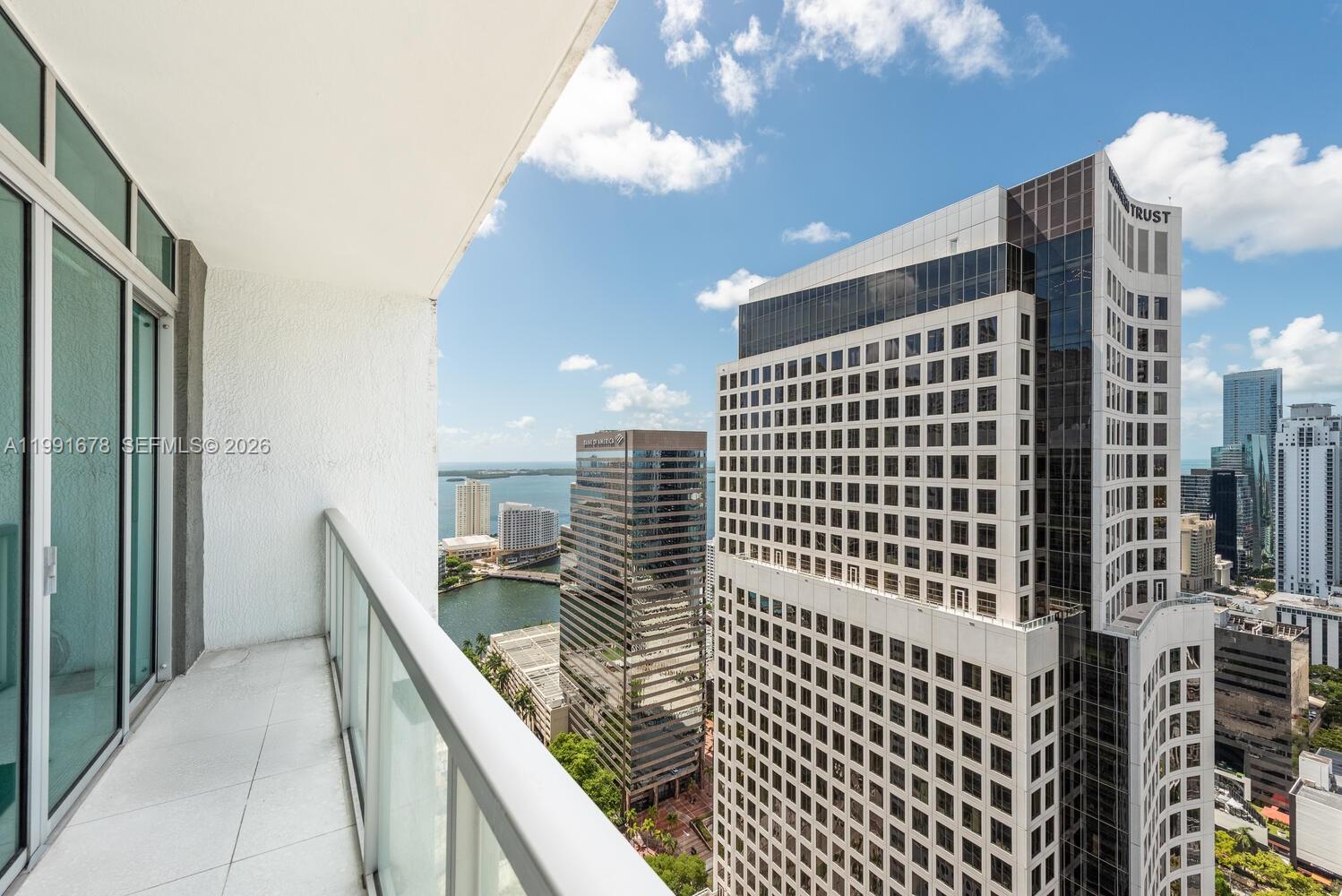 A high-rise balcony overlooks a dense urban skyline with several large office buildings — 55 SE 6th St # 4308, Miami FL 33131, MIAMI, FL