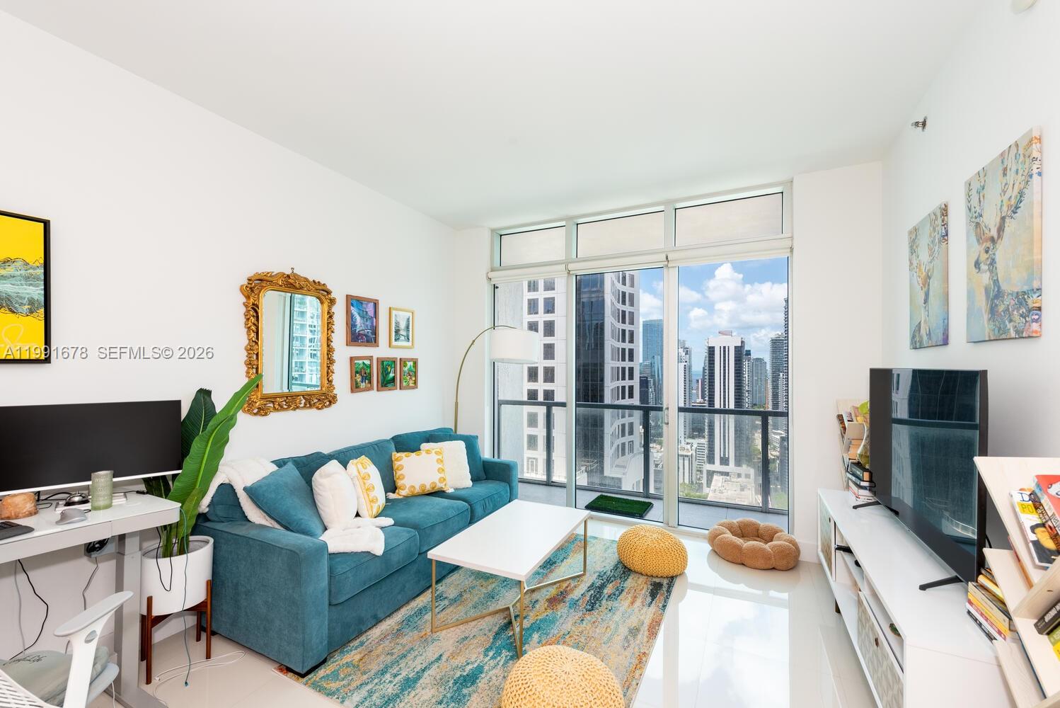 A living room features a blue sofa, a white coffee table, and floor-to-ceiling windows — 55 SE 6th St # 4308, Miami FL 33131, MIAMI, FL
