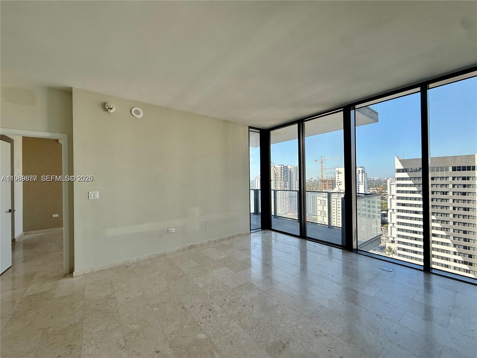 An empty room features light-colored tile flooring, a plain wall, and floor-to-ceiling windows — 88 SW 7th St # 1808, Miami FL 33130, MIAMI, FL