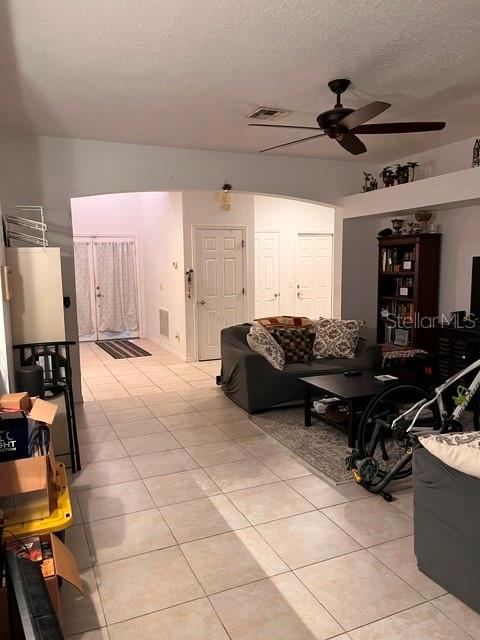 A living room features tile flooring, a ceiling fan, and a gray sofa — 10049 SAVANNAH BLUFF LANE, ORLANDO, FL