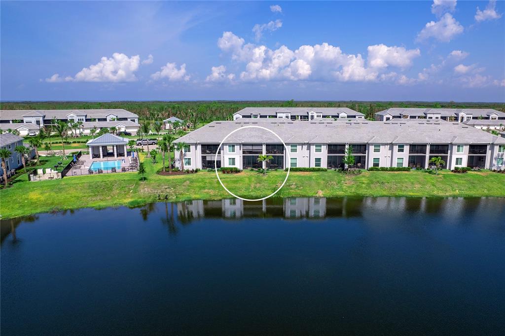 An aerial view shows a multi-unit residential building with a screened patio facing a lake — 14214 HERITAGE LANDING BOULEVARD UNIT 817, PUNTA GORDA, FL