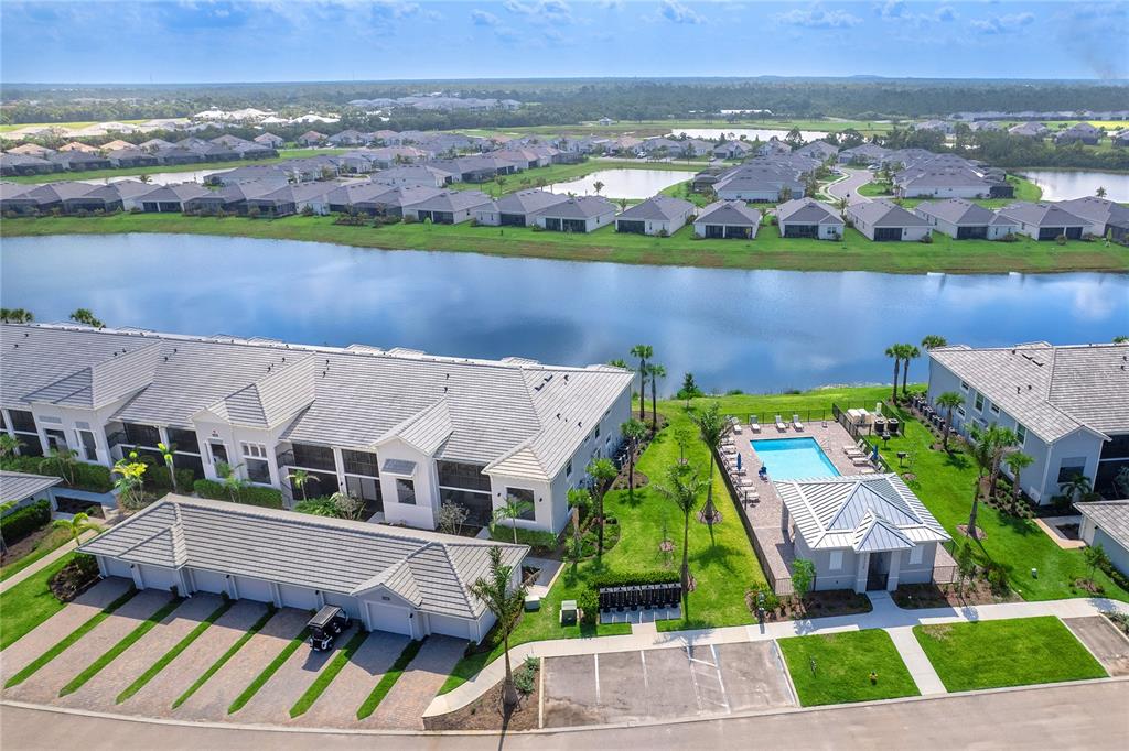An aerial view shows a residential complex with a pool, lake, and parking area — 14214 HERITAGE LANDING BOULEVARD UNIT 817, PUNTA GORDA, FL