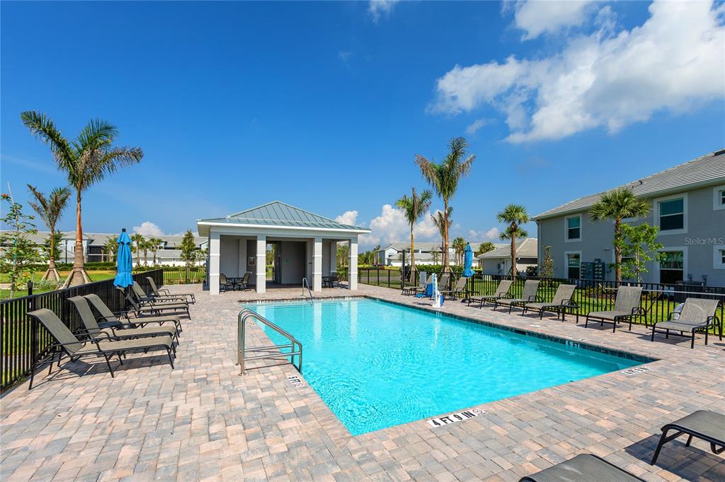A swimming pool with lounge chairs and a covered pavilion under a blue sky — 14214 HERITAGE LANDING BOULEVARD UNIT 817, PUNTA GORDA, FL