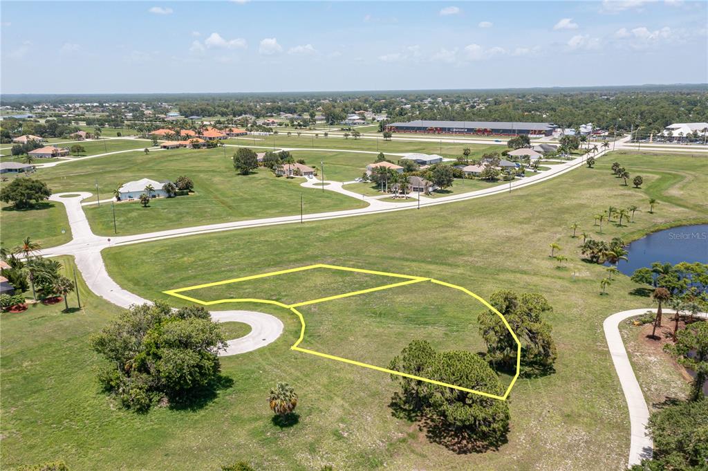 An aerial view shows two adjacent vacant residential lots outlined in yellow near a cul-de-sac — 16494 TOGAS WAY, PUNTA GORDA, FL