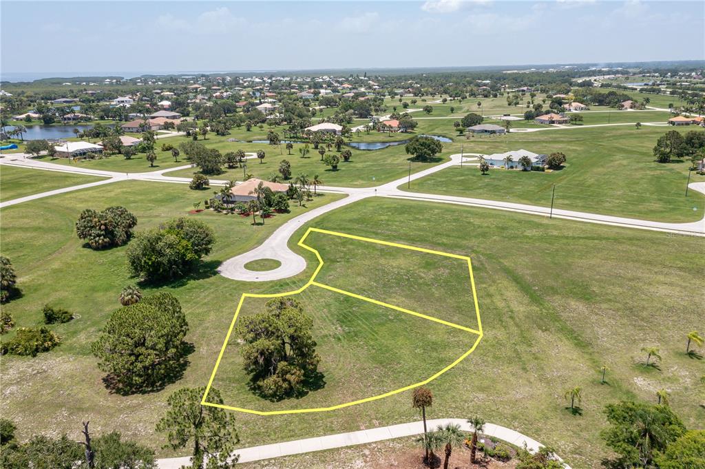 An aerial view shows two adjacent vacant residential lots outlined in yellow on a grassy field — 16494 TOGAS WAY, PUNTA GORDA, FL