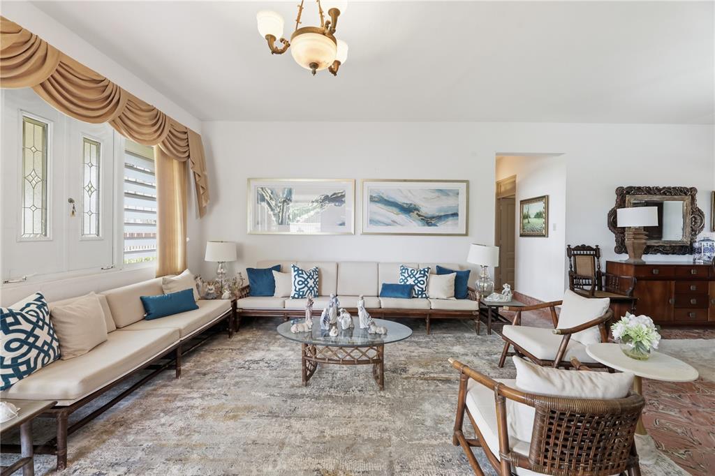 A living room features two sofas, rattan chairs, a glass coffee table, and neutral decor — 241 B AVENUE, FAJARDO, PR