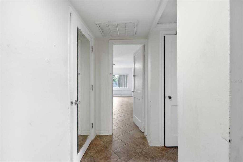 An empty room with beige tile flooring, white walls, a ceiling fan, and double doors — 2041 JEWELL AVENUE, WINTER PARK, FL