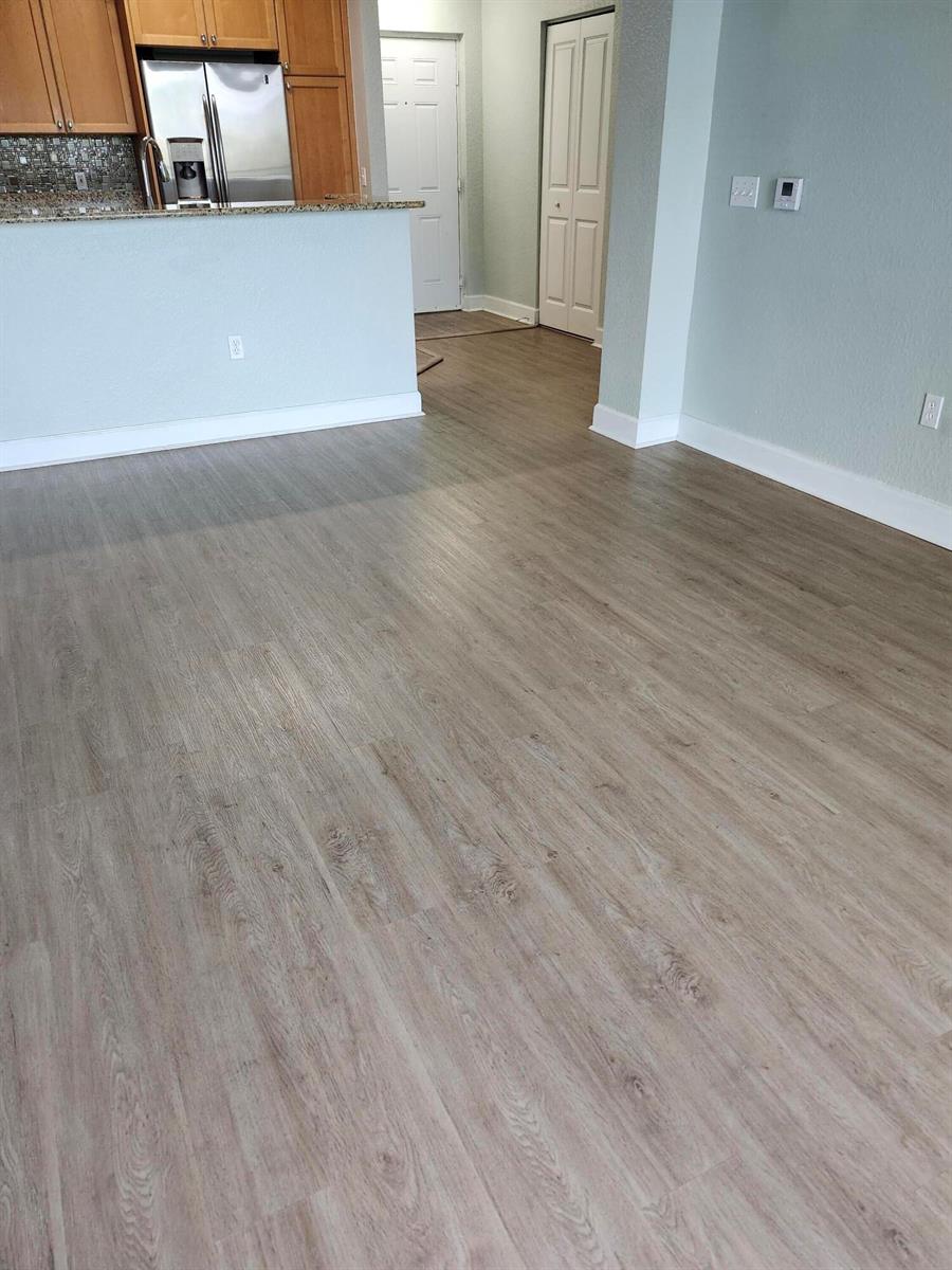 A view of a room with light wood-look flooring and a kitchen counter — 1660 Renaissance Commons Boulevard # 2504, Boynton Beach FL 33426, BOYNTON BEACH, FL
