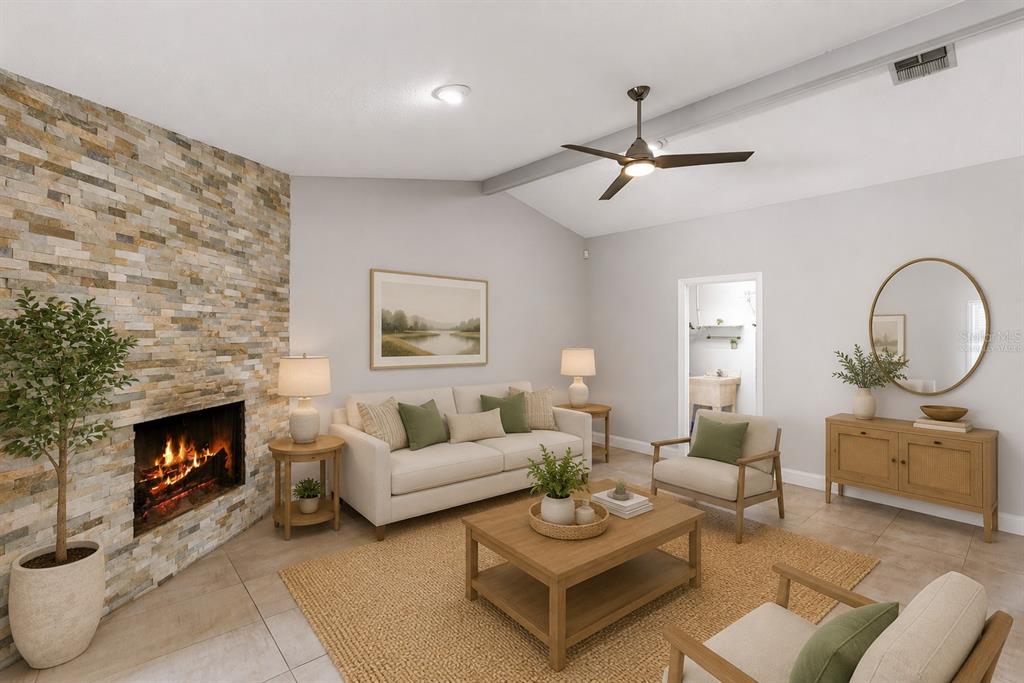 A living room features a stone fireplace, vaulted ceiling, neutral furniture, and a jute rug — 351 NEEDLES TRAIL, LONGWOOD, FL