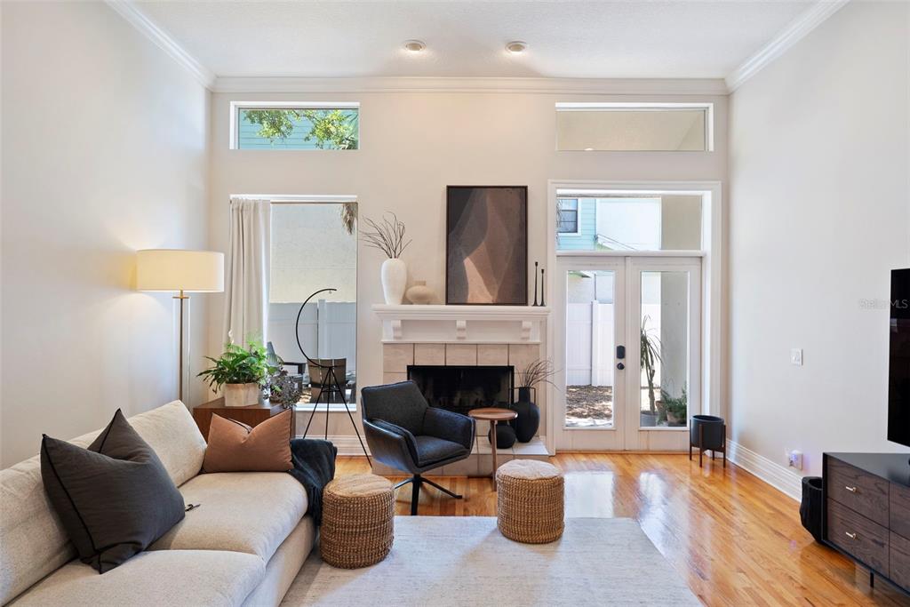 A living room features a fireplace, hardwood floors, high ceilings, and glass doors to outside — 2504 W TENNESSEE AVENUE UNIT A, TAMPA, FL