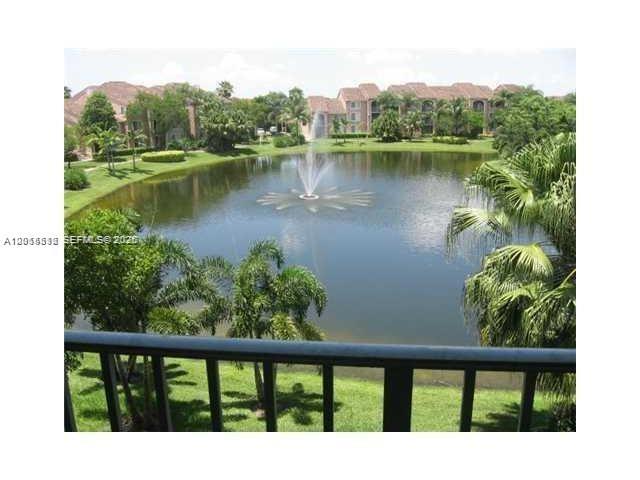 A view from a balcony overlooking a pond with a fountain and surrounding apartment buildings — 12118 Saint Andrews Pl # 304, Miramar FL 33025, MIRAMAR, FL