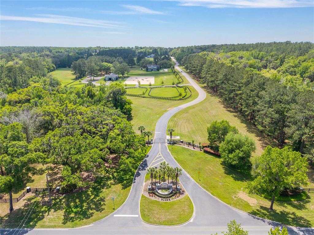 An aerial view shows a gated entrance leading to a long driveway through a rural property — TBD SW 144 COURT ROAD, OCALA, FL
