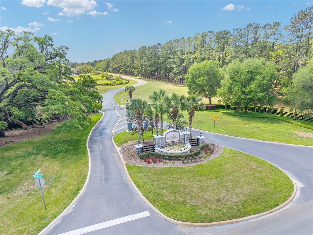 An aerial view shows a gated entrance to a residential community with paved roads — TBD SW 144 COURT ROAD, OCALA, FL