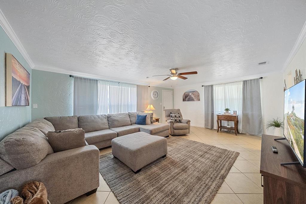 A living room features a large sectional sofa, a central ottoman, and tile flooring — 2135 LEE LANE, SARASOTA, FL