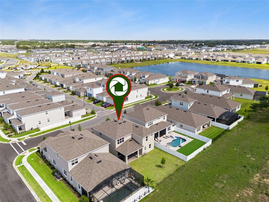 An aerial view shows a two-story suburban house with a backyard pool and fenced lawn — 15652 GENTLE RAIN DRIVE, WINTER GARDEN, FL