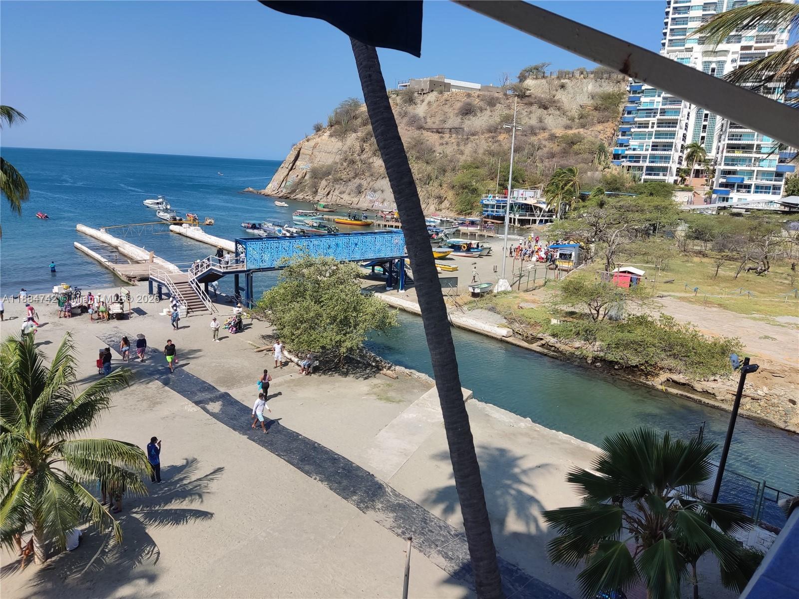 An elevated view shows a beach area with a blue pier, boats, and nearby buildings — Carrera 1a # 5-06, SA 130001, SA