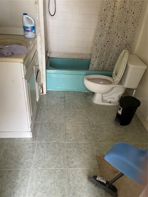 A bathroom features a blue bathtub, a white toilet, a vanity, and light-colored tile flooring — 16148 BOCA RATON STREET, BROOKSVILLE, FL