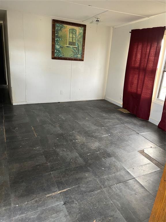 A room with dark square floor tiles, white paneled walls, and maroon curtains — 16148 BOCA RATON STREET, BROOKSVILLE, FL