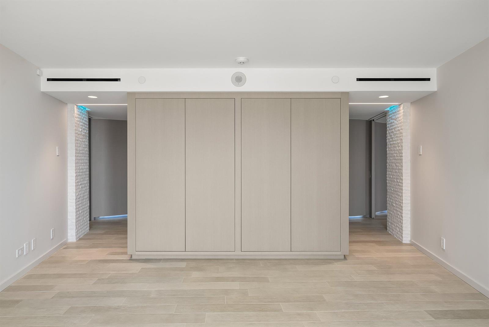 A minimalist room features a central light-wood cabinet unit flanked by two open doorways — 3360 S Ocean Boulevard # i, Palm Beach FL 33480, PALM BEACH, FL