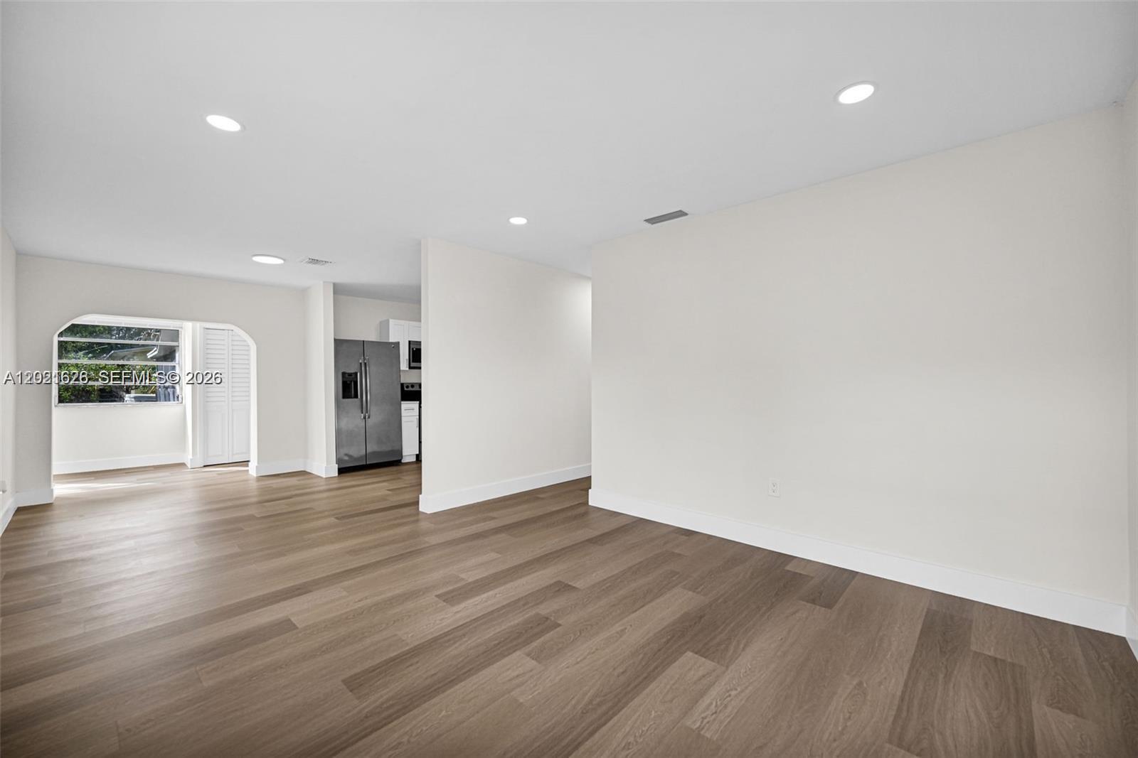 An interior view shows a living area with light-colored walls and wood-look flooring — 11810 NE 14th Ave # 11810, Miami FL 33161, MIAMI, FL