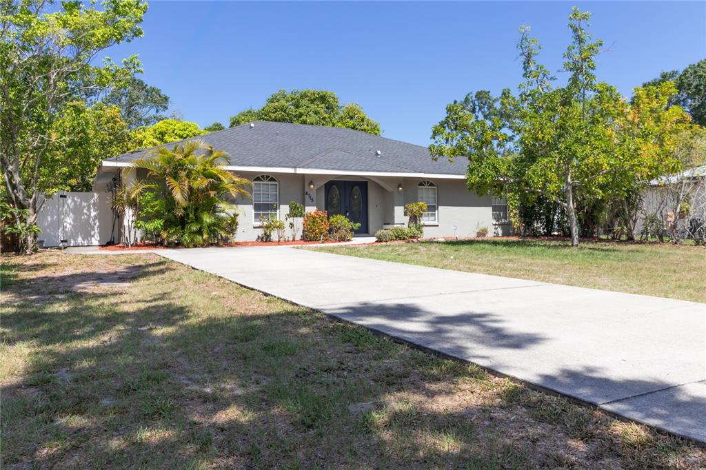 A single-story house with a gray exterior, dark roof, and a concrete driveway — 4715 4TH AVENUE E, PALMETTO, FL