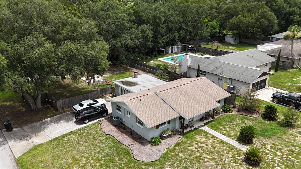 An aerial view shows a gray house with a brown roof, a driveway, and a backyard — 9705 W PIMPERNEL LANE, CRYSTAL RIVER, FL