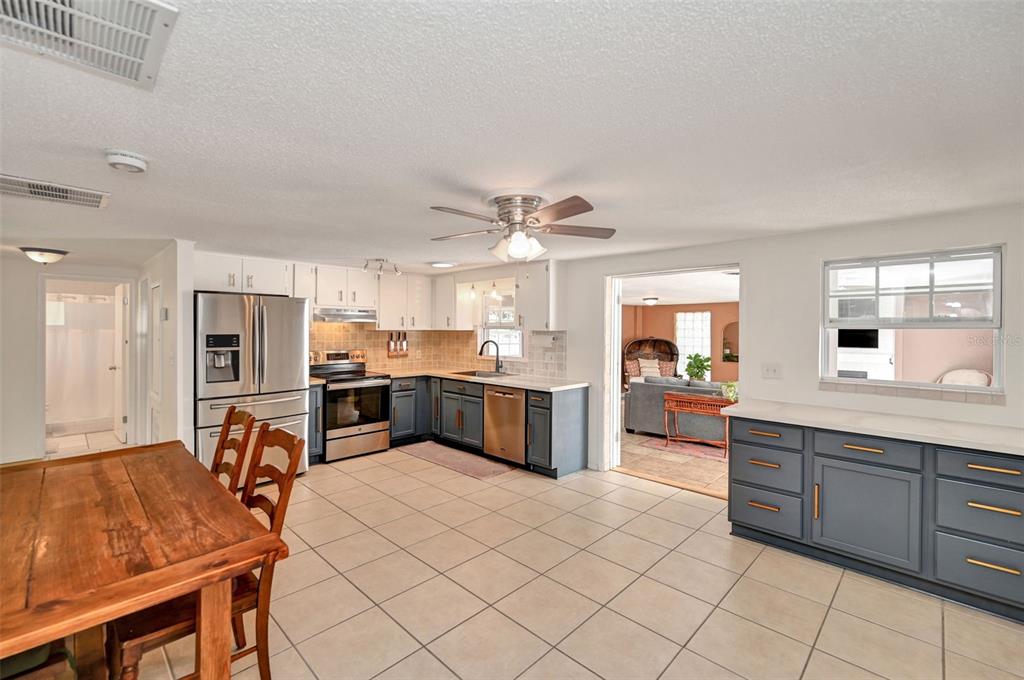A living room features tiled floors, a record storage console, and a kitchen pass-through window — 9705 W PIMPERNEL LANE, CRYSTAL RIVER, FL