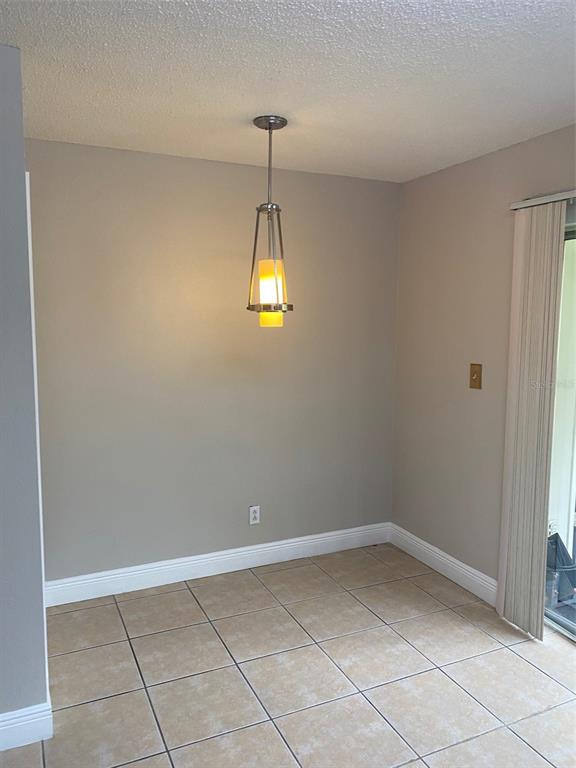 A dining area features beige walls, tile flooring, and a single pendant light fixture — 130 RHODEN LANE, WINTER SPRINGS, FL