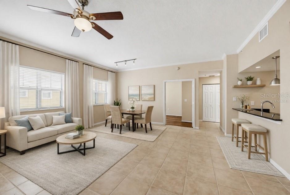 This virtually staged open-concept living and dining area features tile flooring and a breakfast bar — 1064 N TAMIAMI TRAIL UNIT 1406, SARASOTA, FL