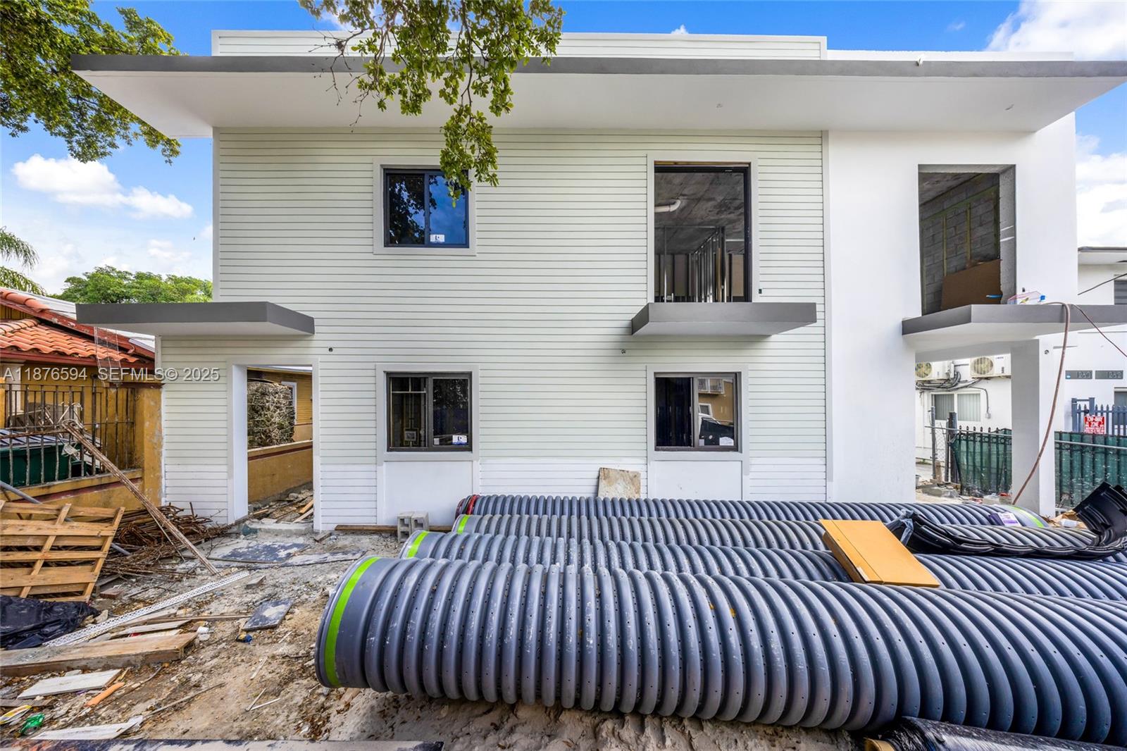 The exterior of a two-story building under construction features light-colored siding and large corrugated pipes — 1254 SW 2nd St, Miami FL 33135, MIAMI, FL