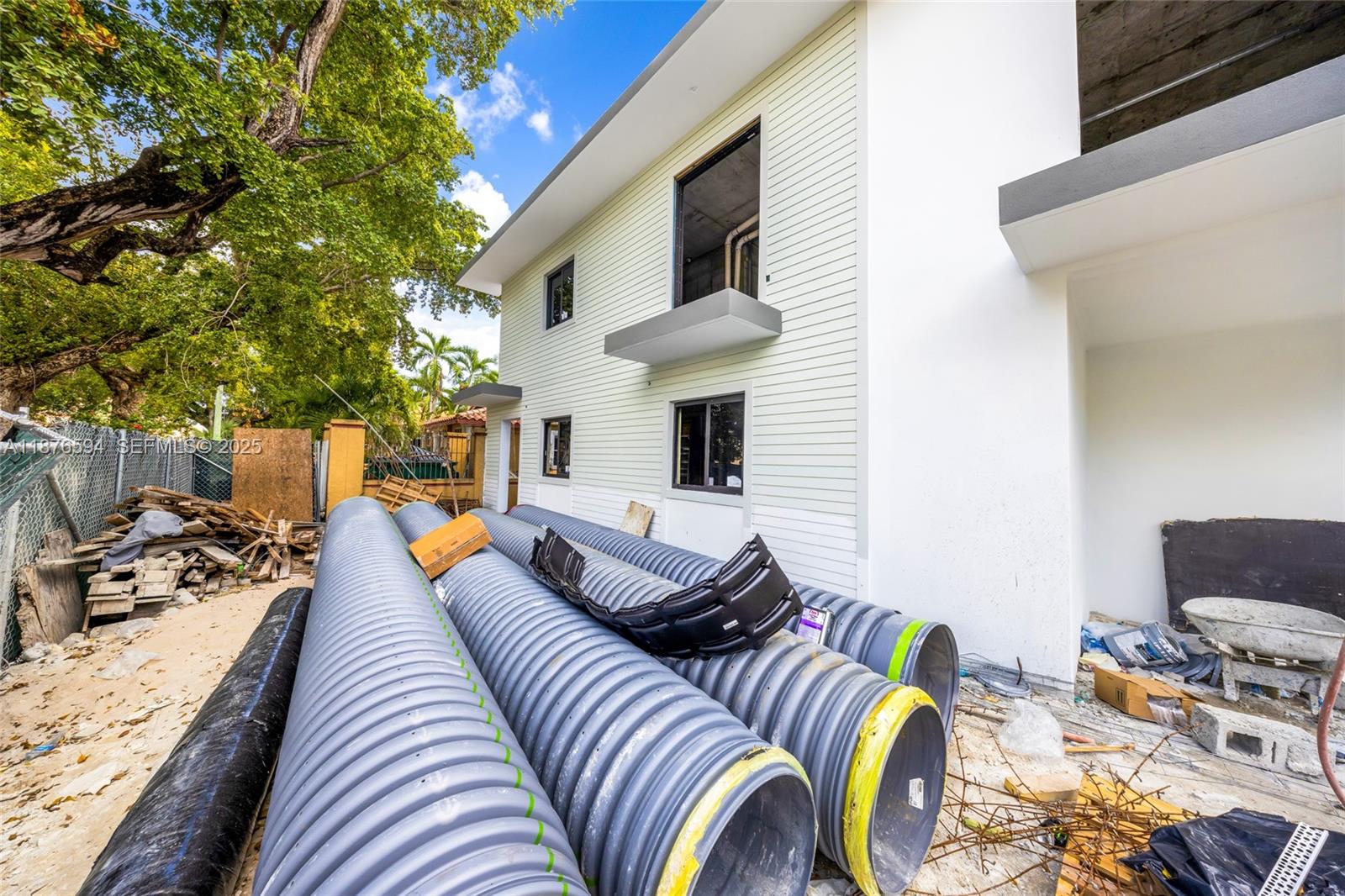 The exterior of a modern house under construction features large corrugated drainage pipes in the foreground — 1254 SW 2nd St, Miami FL 33135, MIAMI, FL