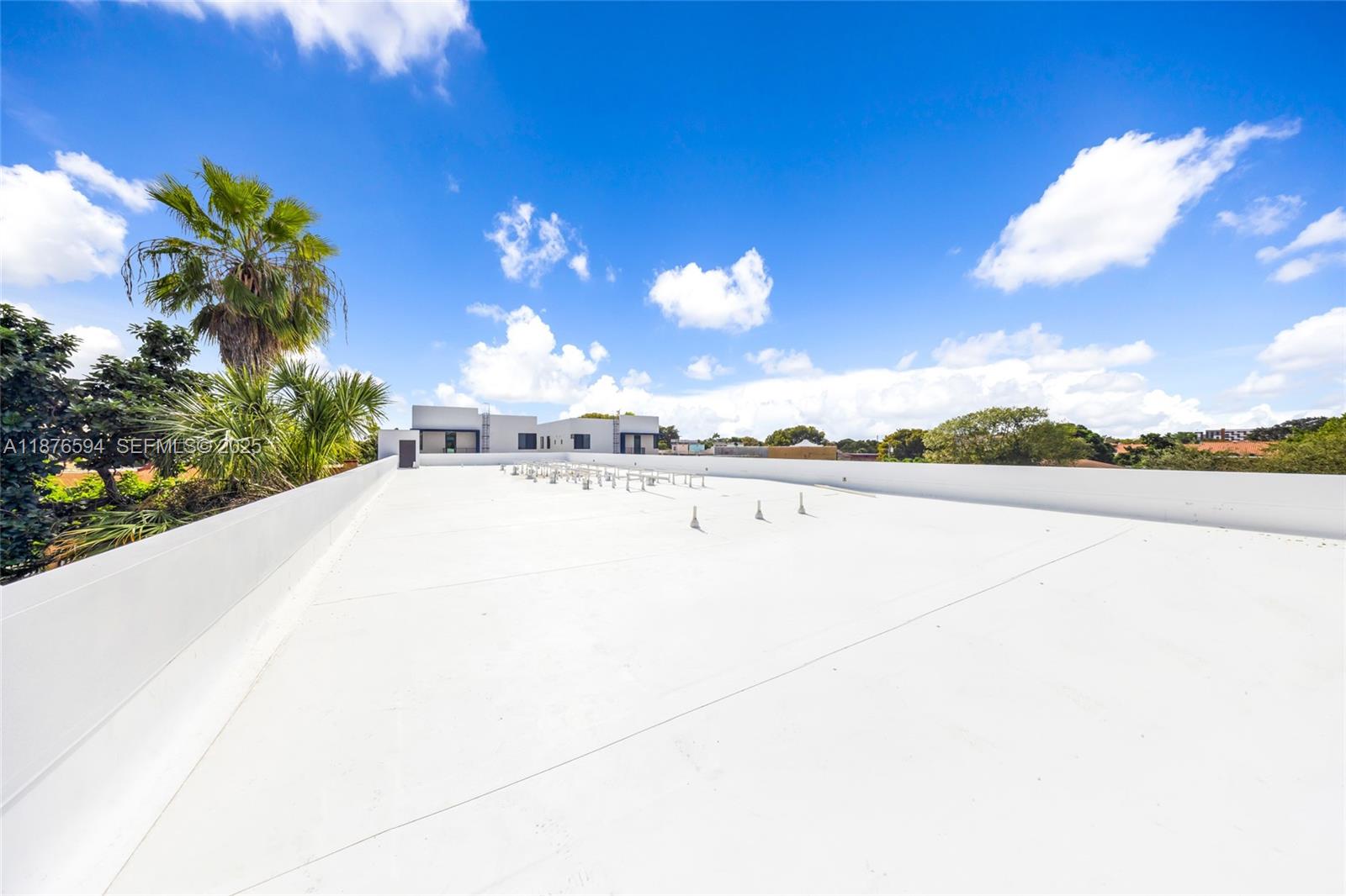 A flat, white rooftop terrace features metal supports under a bright blue sky — 1254 SW 2nd St, Miami FL 33135, MIAMI, FL