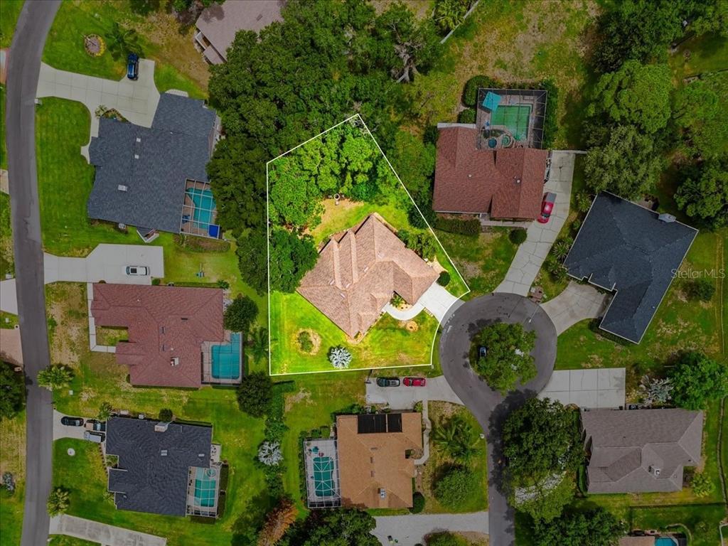 An aerial view shows a single-family home with a brown roof on a corner lot — 3158 BEAUCHAMP COURT, WINTER HAVEN, FL