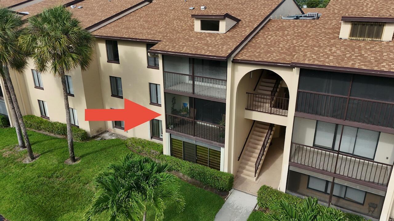 An aerial view of a multi-story apartment building with a screened-in balcony and exterior stairs — 627 Sea Pine Way # C2, FL 33415, FL
