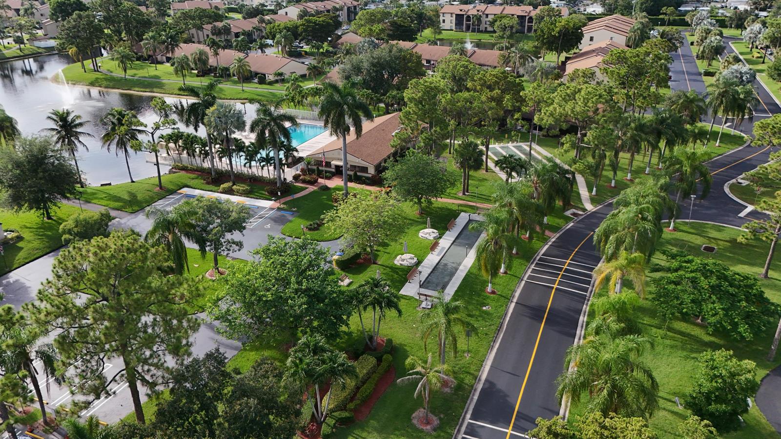Aerial view of a residential community featuring a swimming pool, clubhouse, and landscaped grounds — 627 Sea Pine Way # C2, FL 33415, FL