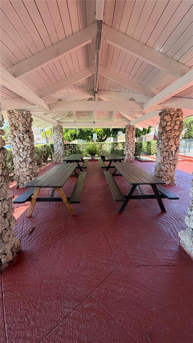 A covered outdoor patio features two picnic tables and stone-clad support columns — 3901 SW 109th Ave # 4, Miami FL 33165, MIAMI, FL