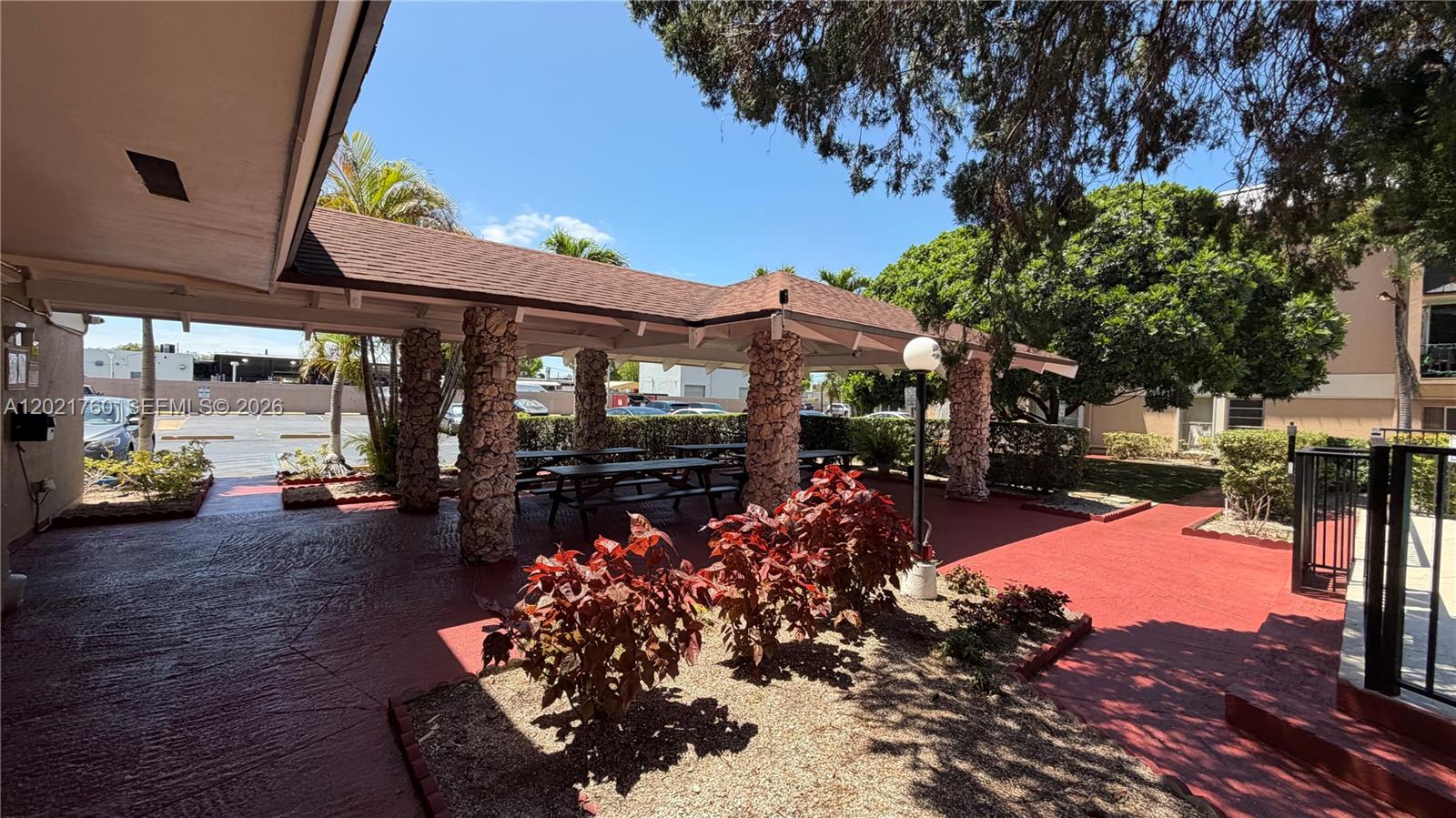 A covered outdoor patio features stone pillars, picnic tables, and red painted concrete flooring — 3901 SW 109th Ave # 4, Miami FL 33165, MIAMI, FL