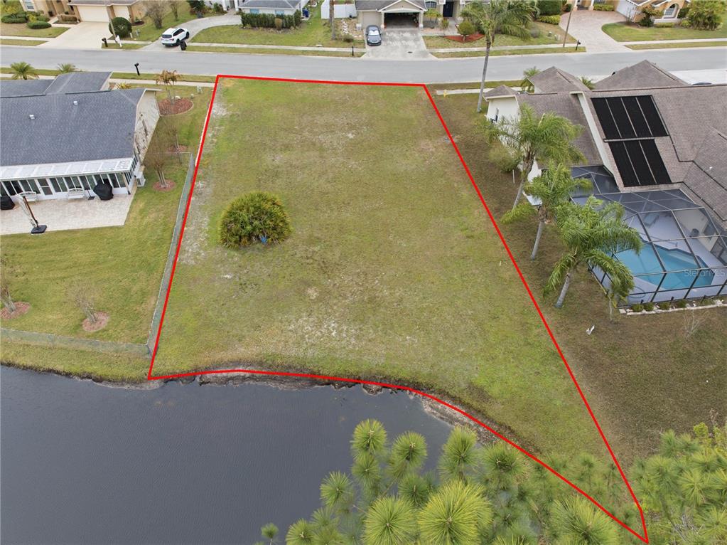 An aerial view shows a vacant residential lot outlined in red bordering a small pond — 1522 HAVERHILL DRIVE, NEW PORT RICHEY, FL
